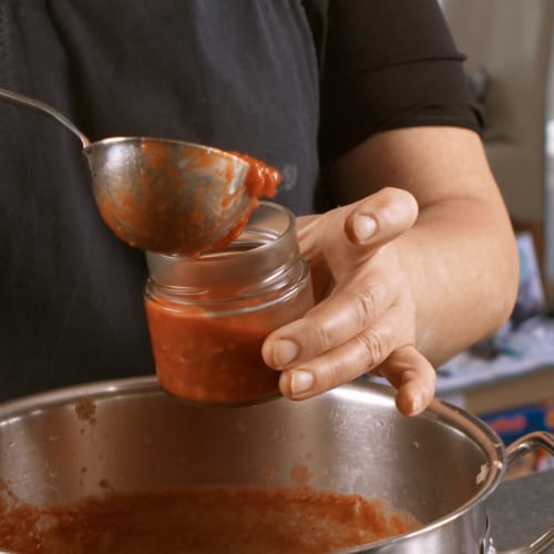 Frisch gekochtes Sugo Abfüllen in hauseigener Manufaktur 